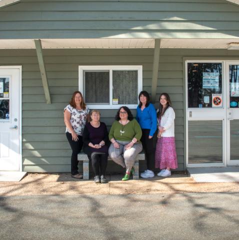 5 women standing in front of a building