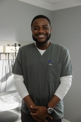 male nurse in grey scrubs standing in an office