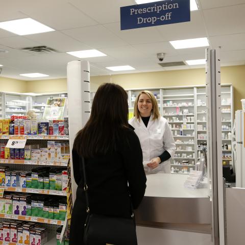 Pharmacist serving prescription to patient