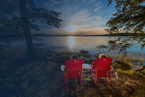 2 people sitting on chairs beside the water in Keji